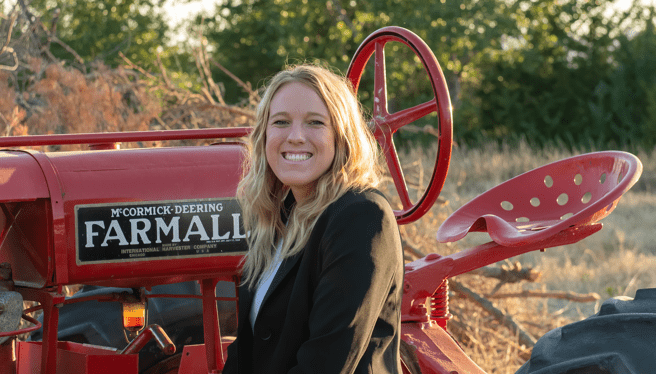 young woman in front of a tractor 